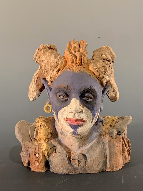 Decorative sculpture of a face with a neutral expression on a gray background