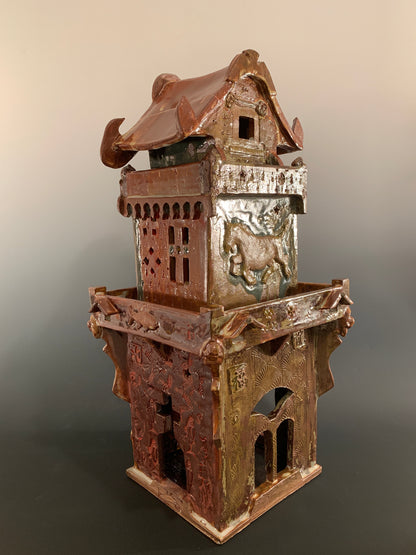 Decorative ceramic house with intricate design on a gradient background