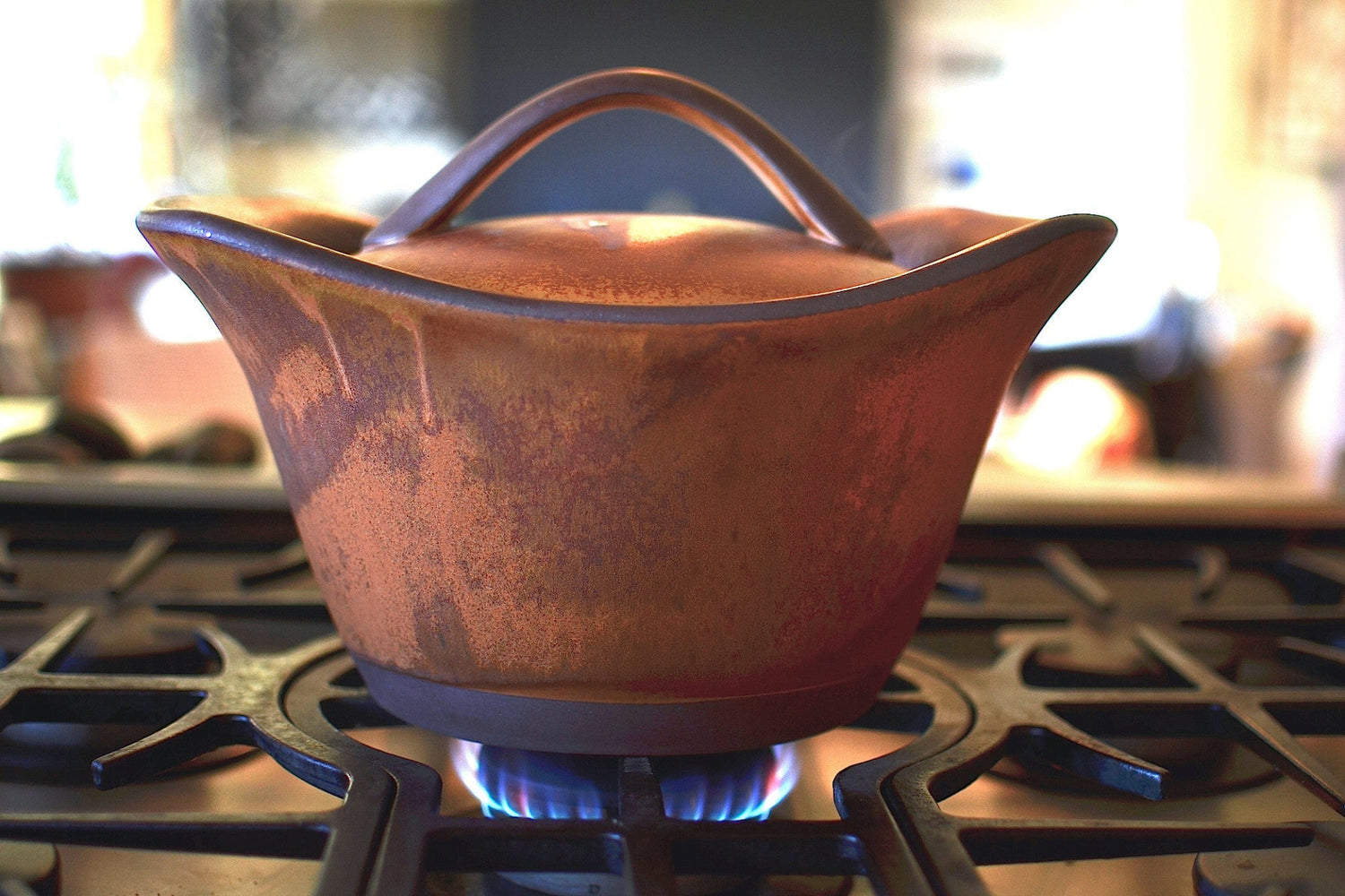 Ceramic pot on a gas stove with a blurred background