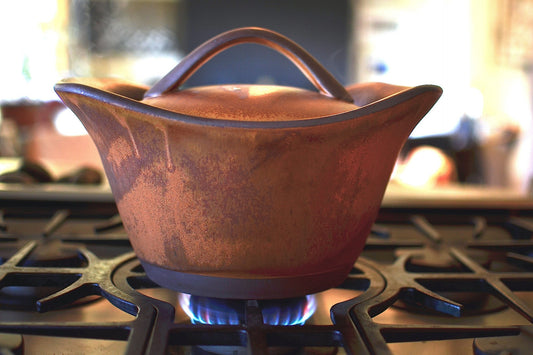 Ceramic pot on a gas stove with a blurred background