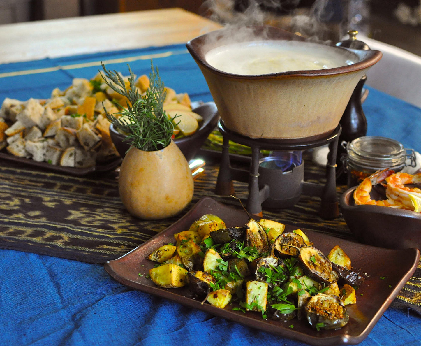 Hot pot with various ingredients on a blue tablecloth