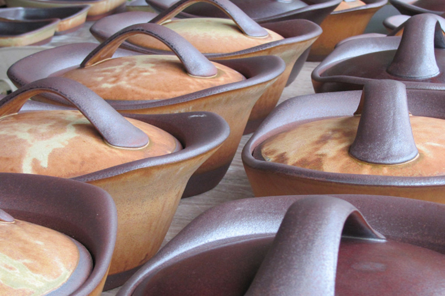 Collection of ceramic pots with lids on a wooden surface