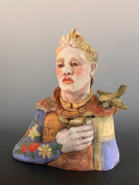 Colorful figurine with a stylized face and floral elements on a gradient background