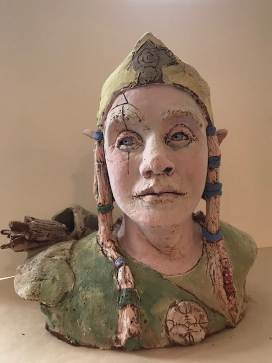 Ceramic bust of a figure with a headdress on a beige background