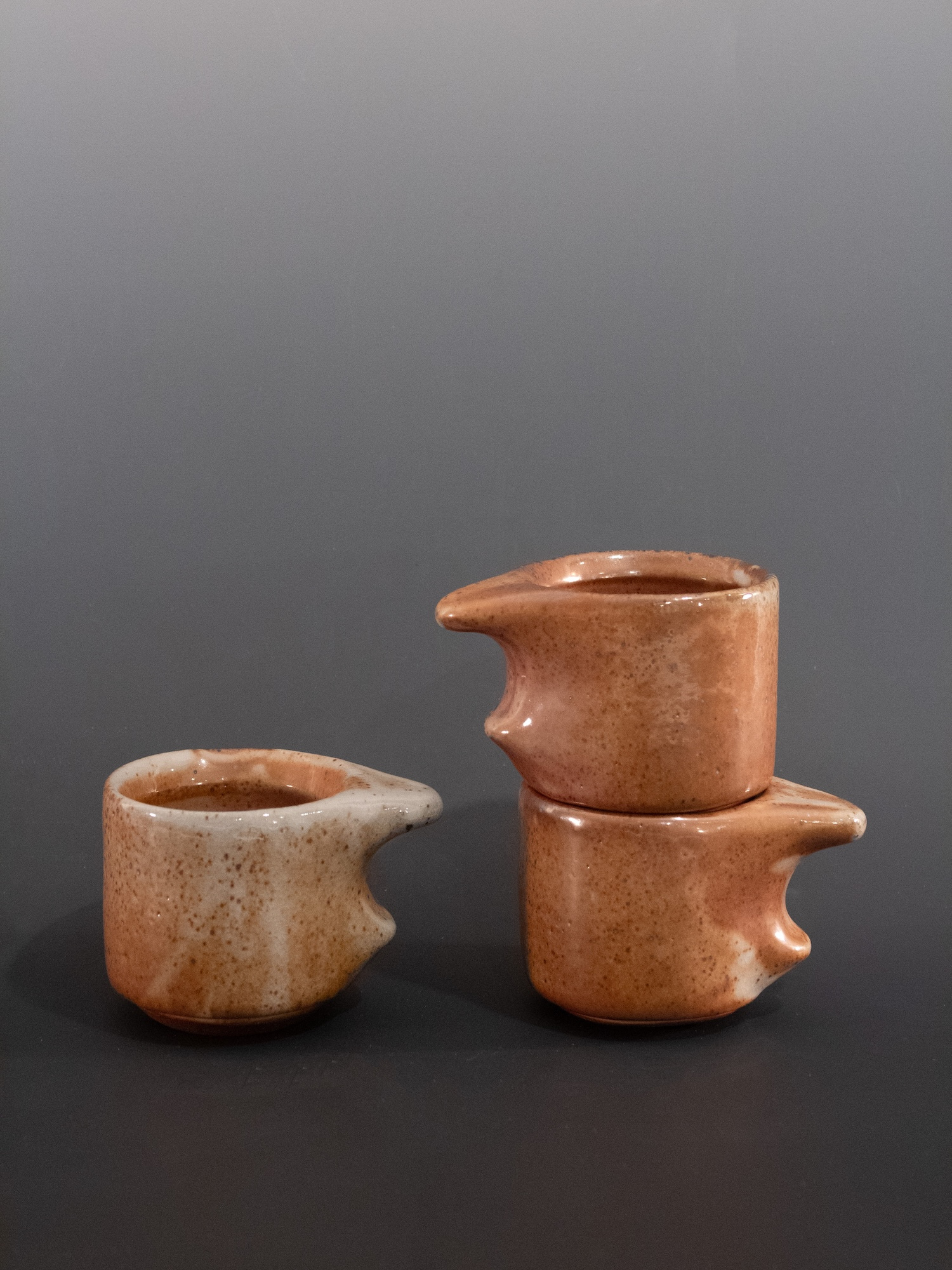 Three ceramic cups on a dark background