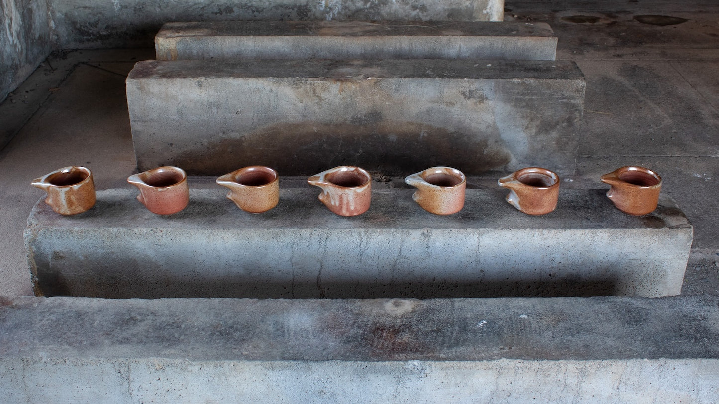 Row of ceramic cups on a stone ledge