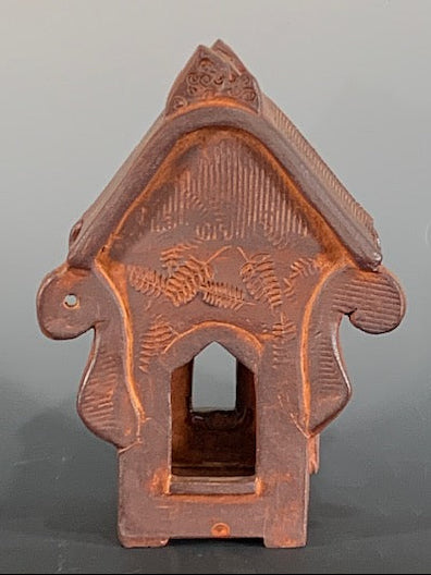 Ceramic decorative house with intricate design on a gray background