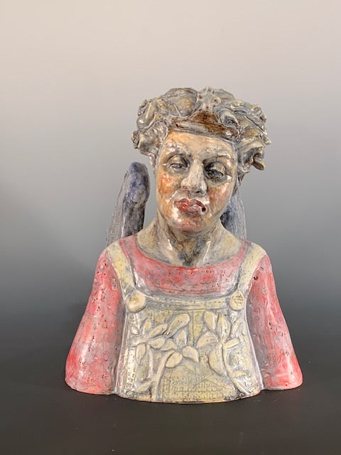 Decorative ceramic bust of person with wings on a gray background