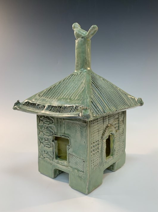 Green ceramic structure with a roof on a white background