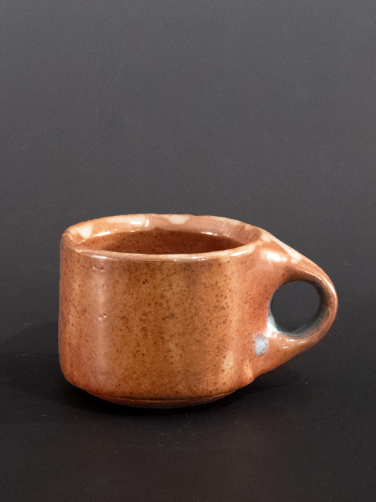 Brown ceramic cup on a black background