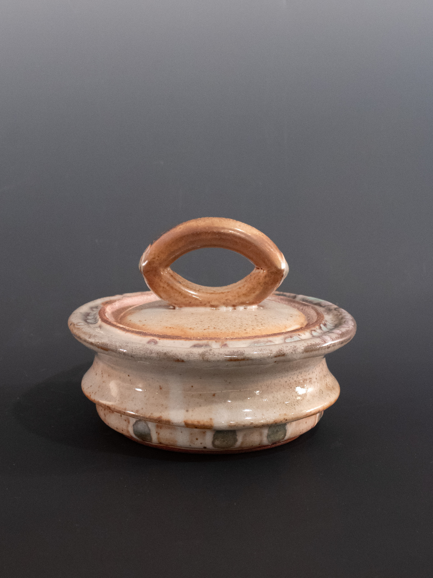 Ceramic container with a handle on a dark background