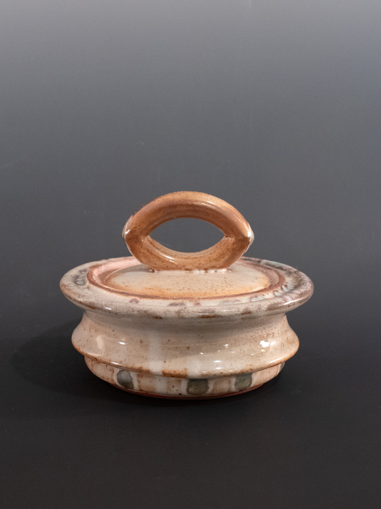 Ceramic container with a handle on a dark background