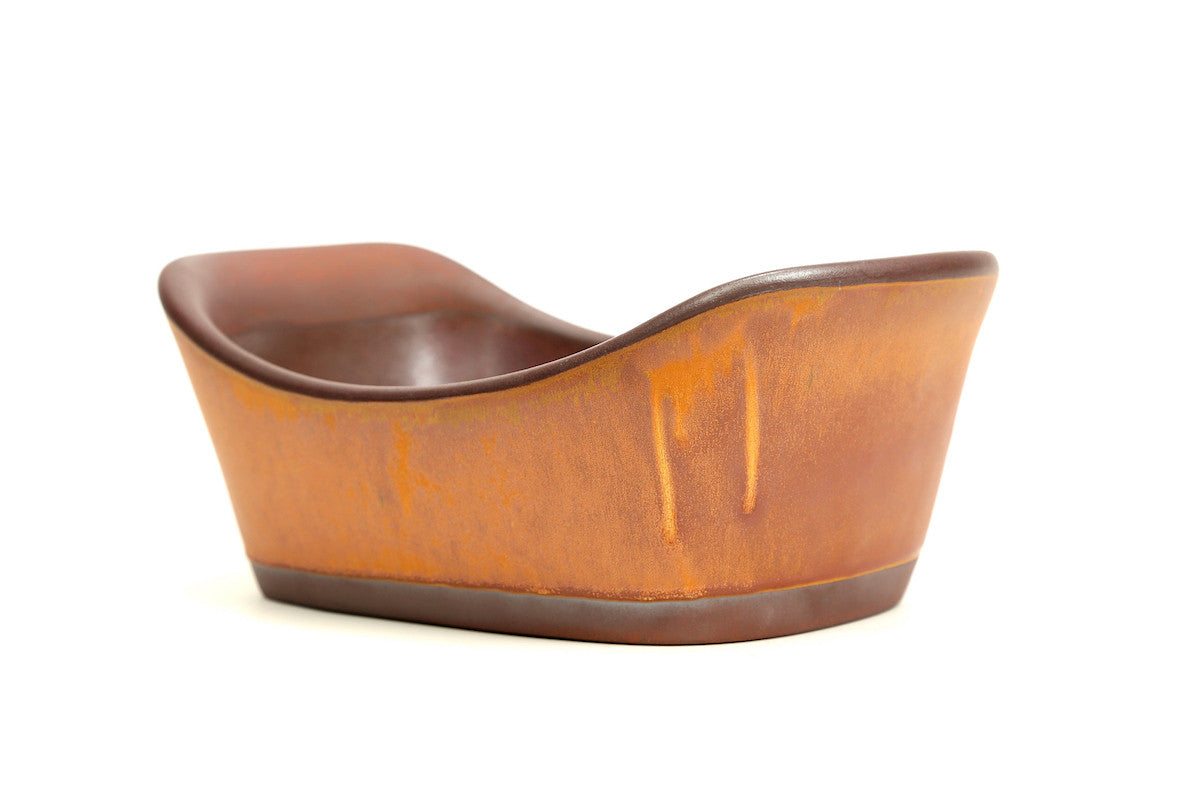 Brown ceramic boat-shaped object on a white background