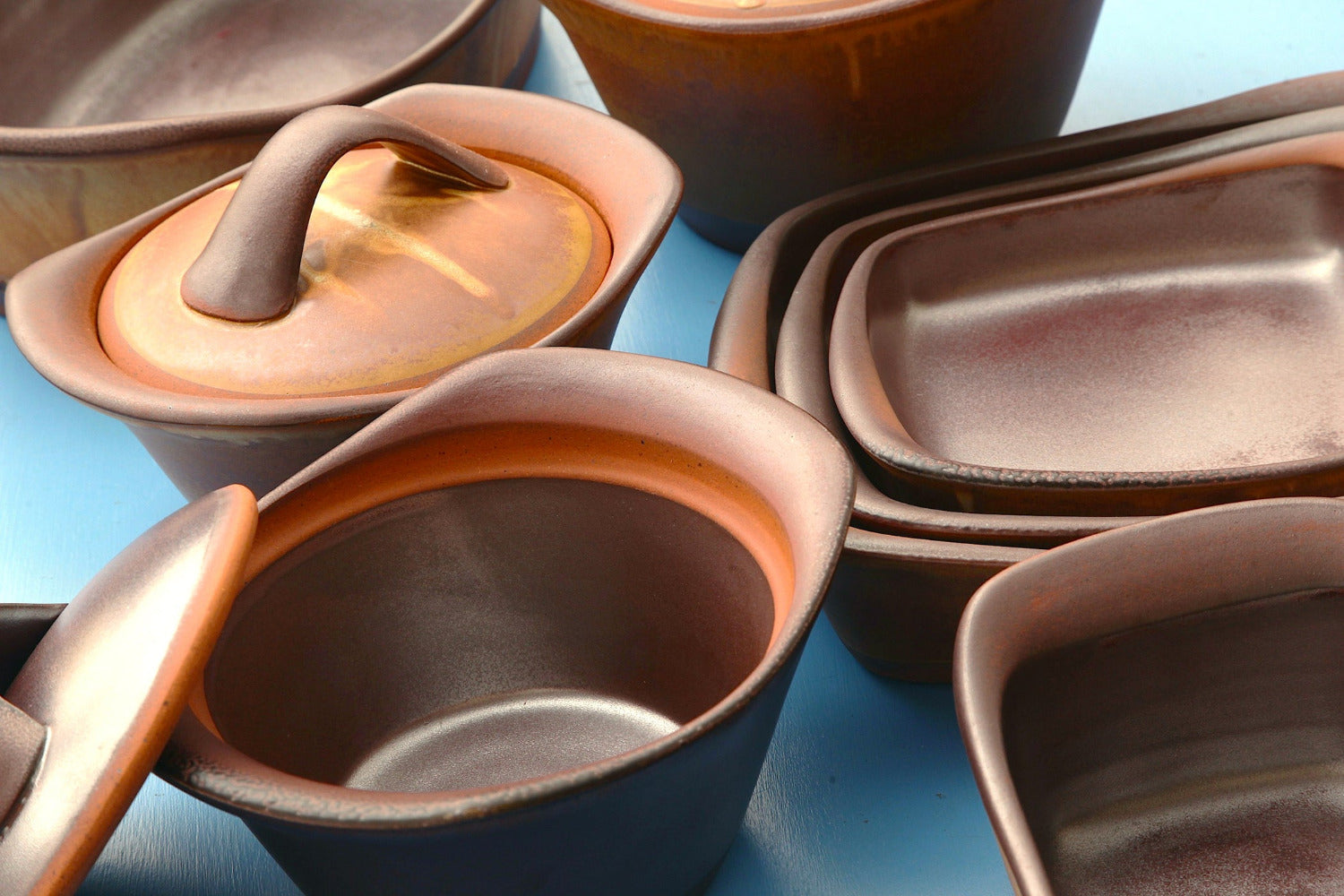 Set of ceramic containers with lids on a blue background