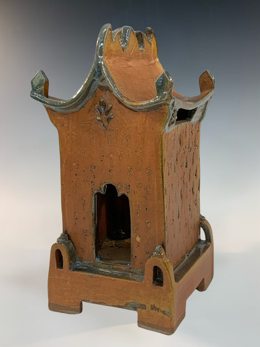 Ceramic brown house with a traditional design on a gray background