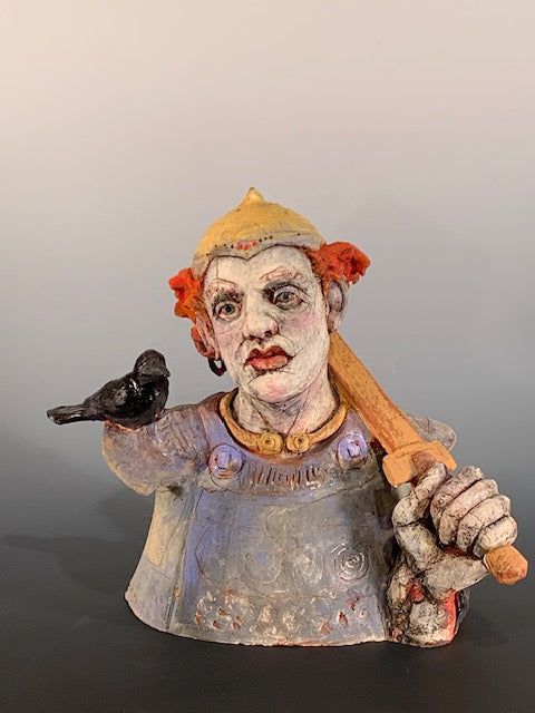 Ceramic bust with colorful face and clothing on a plain background