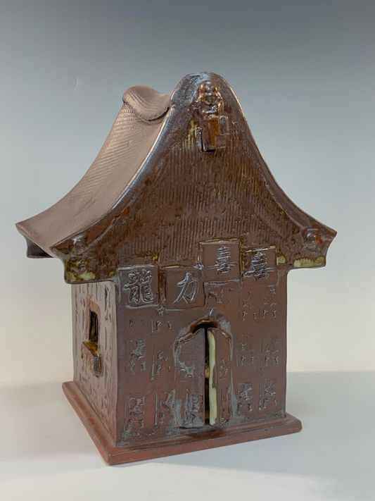 Brown ceramic house with decorative details
