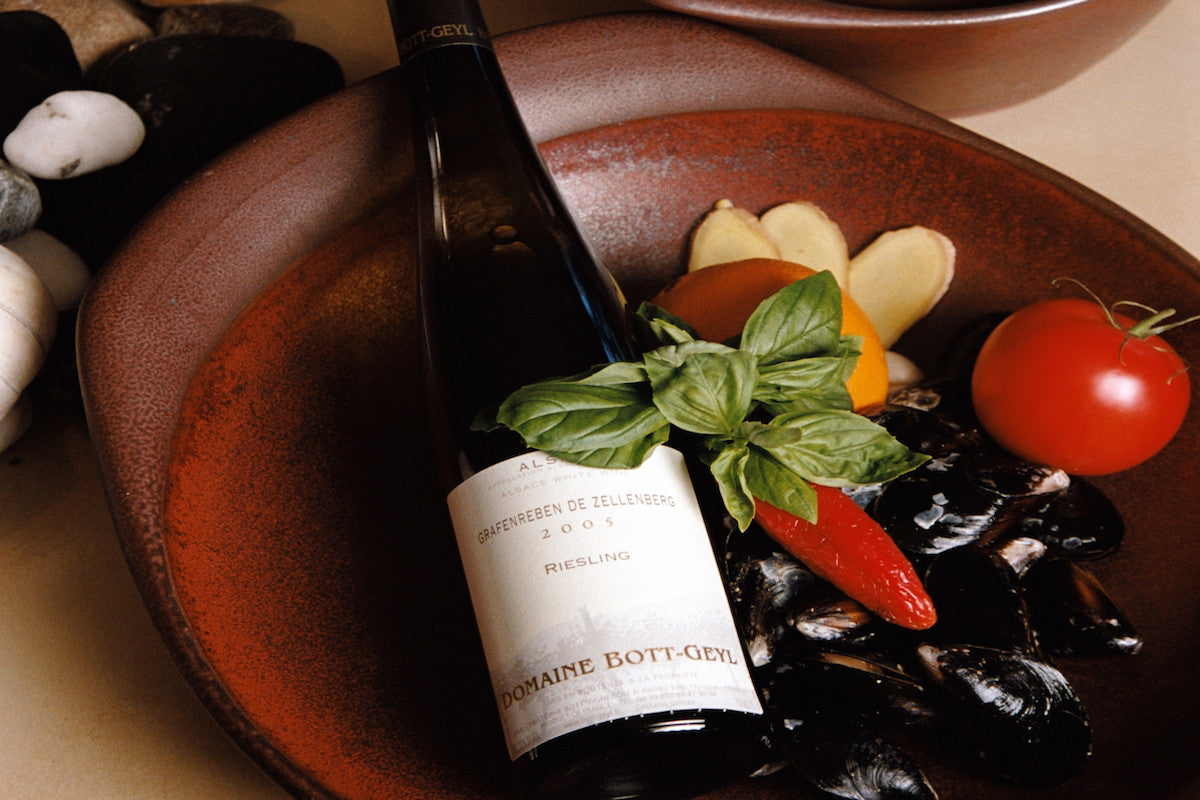 Bottle of wine on a plate with vegetables and mussels