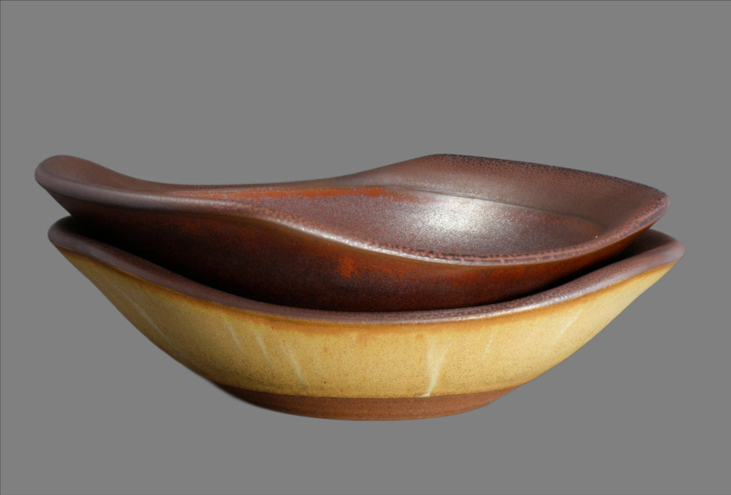 Two ceramic bowls stacked on a gray background