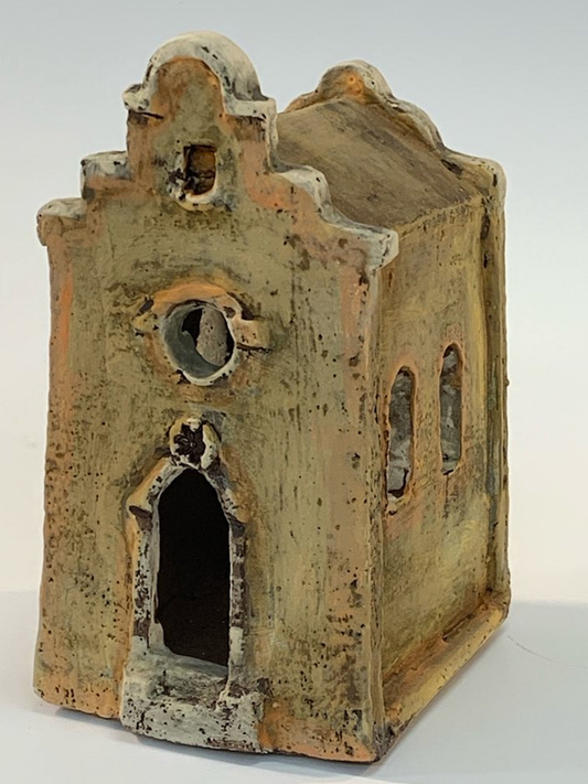 Small ceramic building with a textured surface on a white background