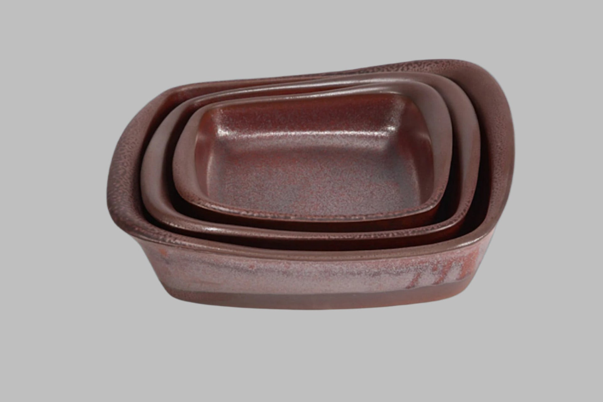 Set of three brown ceramic containers on a gray background