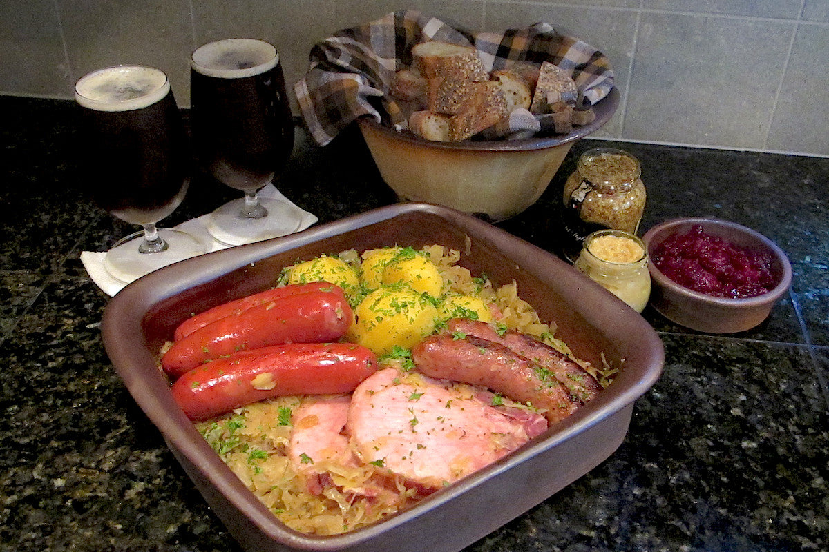 Dish of sausages and rice with sides on a countertop