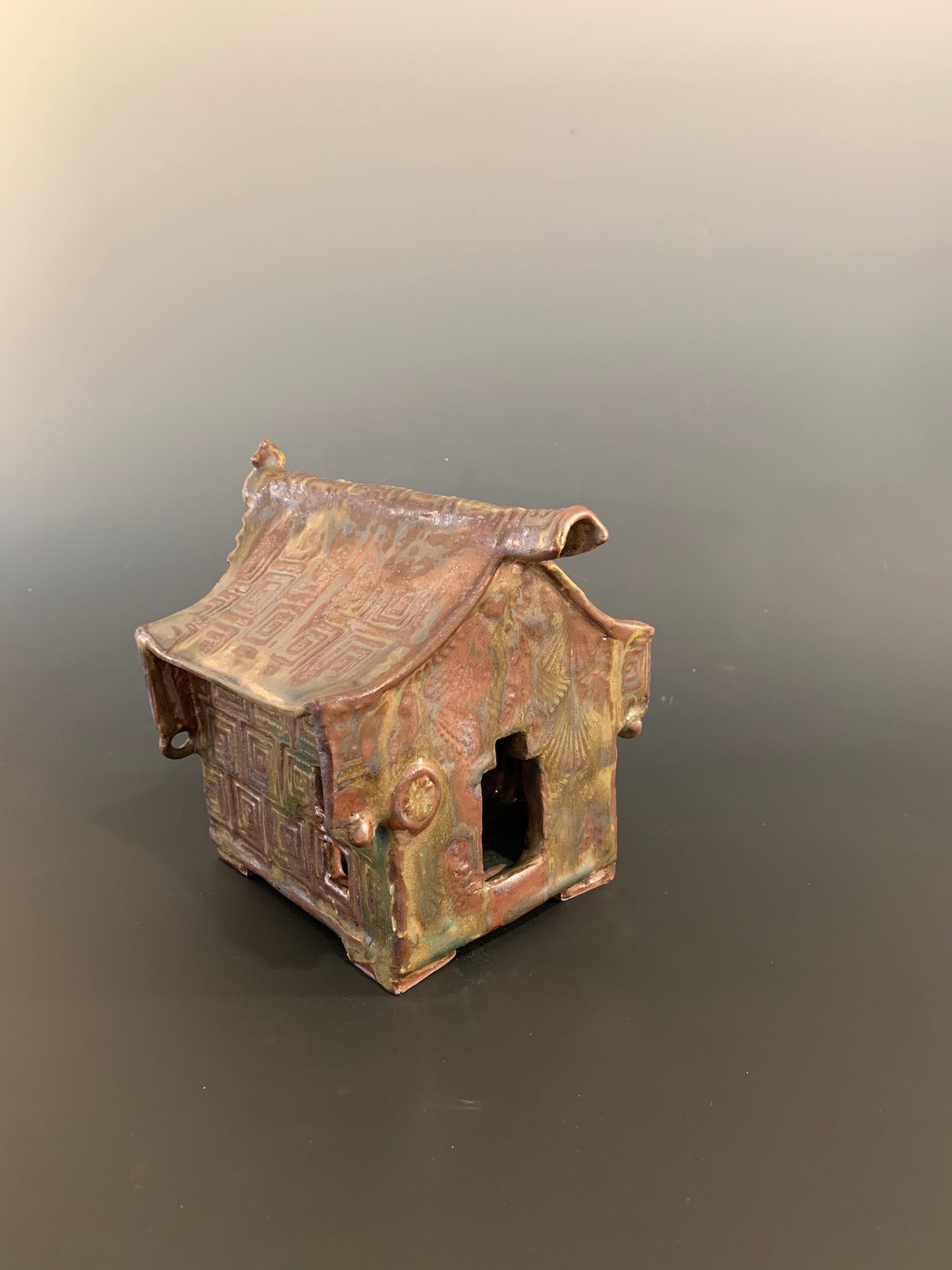 Small ceramic model of a traditional building on a gray background